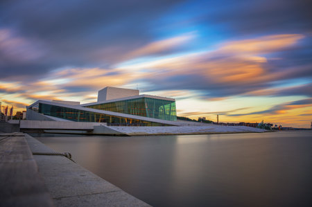 Oslo, Norway - July 30, 2024 : Oslo Opera House at sunset with calm fjord waters and colorful sky. Long exposure.のeditorial素材