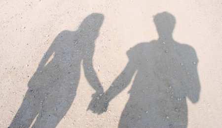 Shadow of couple holding handsの写真素材