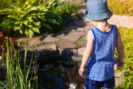the child is looking at the pondの写真素材