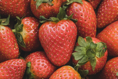 A close up of a bunch of strawberries. The center strawberries reminds of a heart because its shape.の写真素材