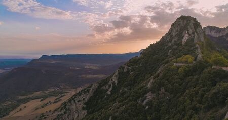 Landscape in which several mountains are observed and the sunset behind a large mountain that is to the right of the image.の写真素材