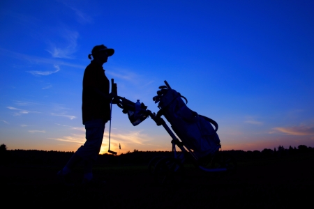 Golf, woman golfer with golf bag at sunset, as backgroundsの写真素材