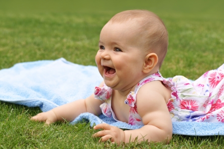 Baby, girl, seven-month-old child lying on a blue blanketの写真素材
