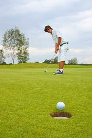 Golf, Golfer thrusting the ball into the holeの写真素材