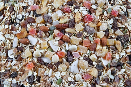 Breakfast cereals, oatmeal with candied fruits, raisins and nuts, as background