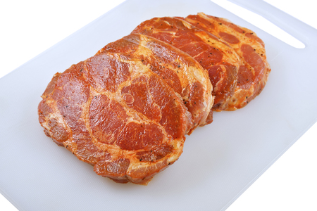 Meat, Pork neck in marinade and on a chopping boardon, on a white backgroundの写真素材