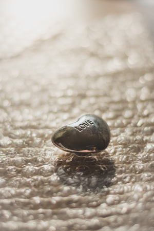 small love heart stone on a bubble wrap it from the back by sunの写真素材
