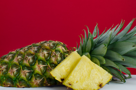 sliced pineapple fruit on red background, horizontalの写真素材