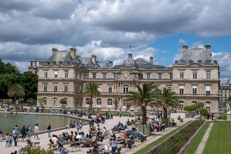 PARIS, FRANCE - JUNE 6, 2022: Tourists relaxing in Luxembourg Garden (Jardin du Luxembourg),second...