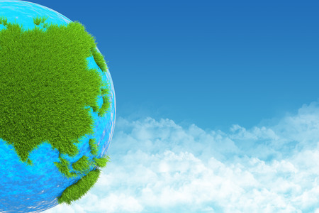 globe with green grass on background skyの写真素材