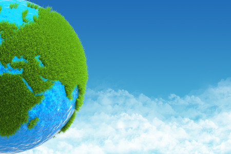 globe with green grass on background skyの写真素材