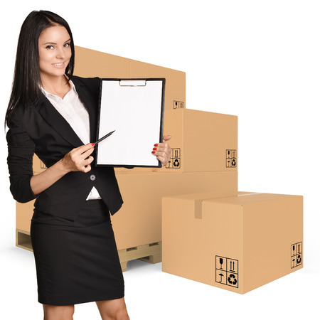 Woman standing with cardboard boxes and showing in clipboard.の写真素材