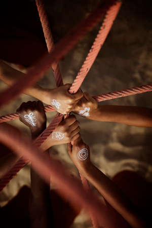 Black hands together between rope at the beachの写真素材