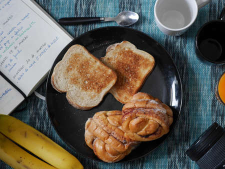 A plate of breakfast with a notebook and a camera. Planning the day