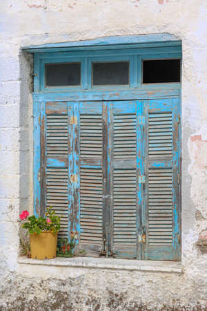 closed shutters at old window with flowers, Paros, Greeceの写真素材