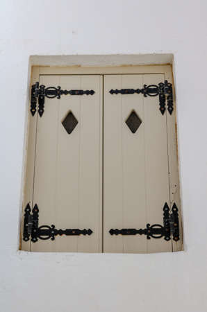 White shutters with diamond shaped windowsの写真素材