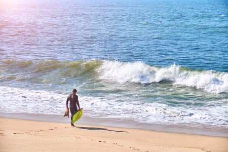 Surfer on the beach and in ocaen water