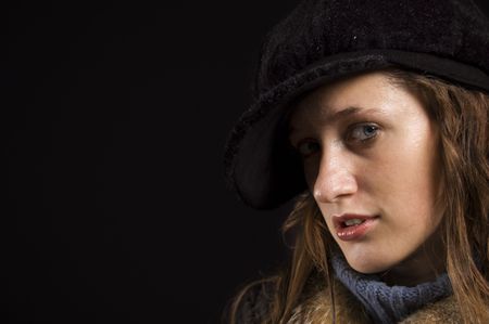 Warm dressed young woman on black background in studio