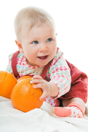Adorable 10 month baby-girl playing with orangesの写真素材