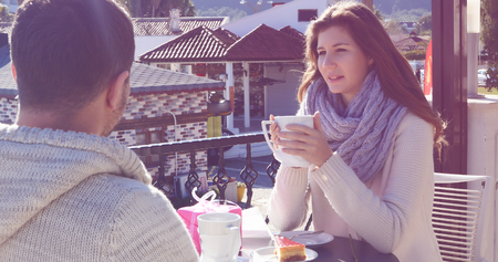 Young couple man with hot coffee in outdoor cafeの写真素材