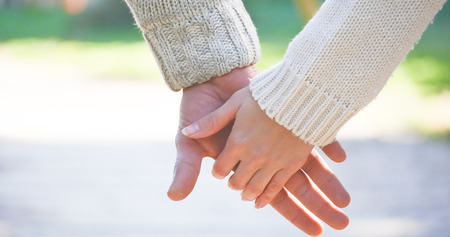 Closeup of young couple holding hands