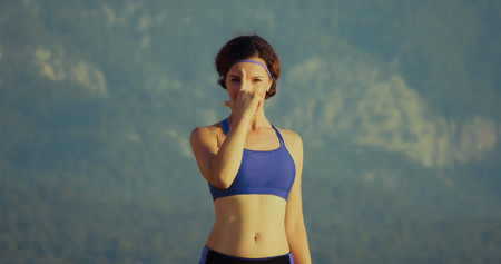 Front view portrait of beautiful young woman wearing sport topic and doing yogaの写真素材
