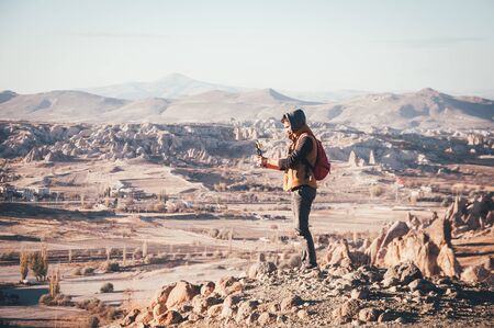 Man traveler taking photos with gorilla pod of beautiful panoramic view in Cappadocia in autumn timeの写真素材