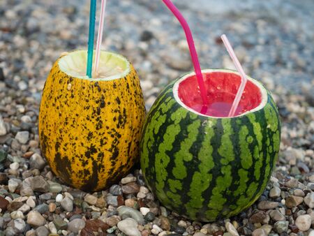 Fresh two melon and watermelon cocktails on the beach by the seaの写真素材