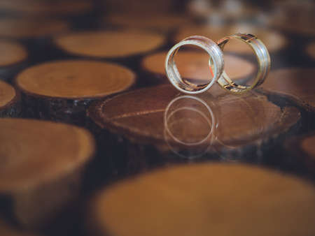 Closeup of wedding rings on unusual design table of glass and wood.の写真素材
