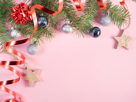 Festive Christmas background. Fir tree branches with christmas decorations on pink background. Flat lay, top view.の写真素材