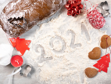 Flat lay of homemade Christmas cookies, dough, decorations and number 2021 made of flour on tableの写真素材