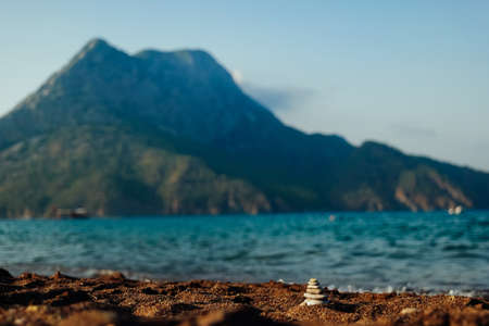 Beautiful Adrasan, Turkey. Mediterranean sea and mountain view on sunset. Small stone pyramid in front viewの写真素材