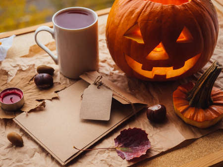 Happy Halloween day background with jack o lantern pumpkin, autumn leaves and greeting envelope. Empty space for text