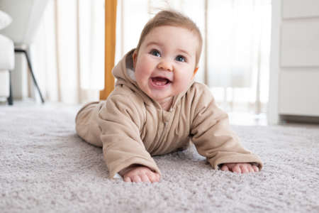Happy baby crawling on floor or carpet. Exploring world. Fluffy carpetの写真素材