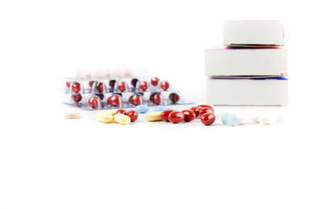 Variety of different pills and capsules, packs on white table. Healthcare and Medicine