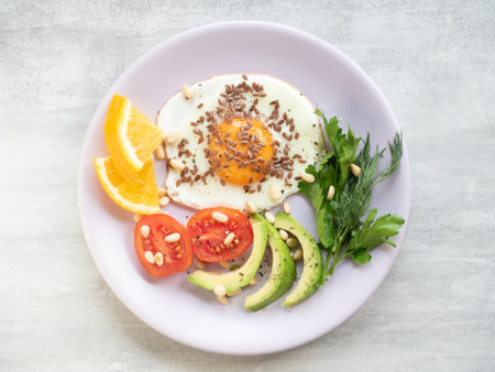 Top view of fried egg with fresh vegetables on a plate. Healthy breakfastの写真素材