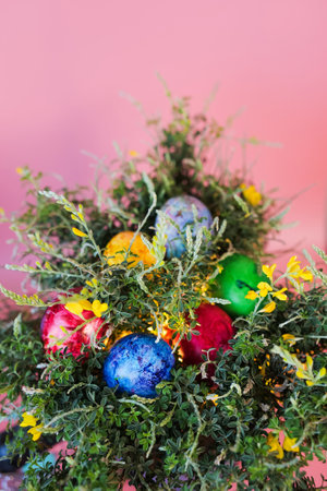Beautiful bouquet of spring blooming bush with easter eggs on pink background. Happy easter greeting...