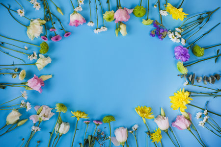 Frame of beautiful colourful summer bouquet separate flowers on blue background. Fresh summer...