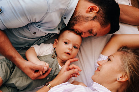 Young happy family. Careful young caucasian parents playing with their little cute baby boy in living roomの写真素材