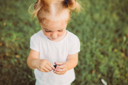 2 year old toddler girl eating ripe black mulberries. Healthy lifestyle, summer vacation.の写真素材
