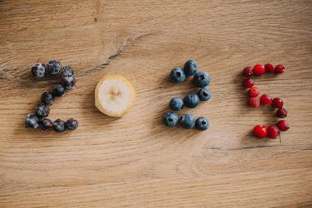 Colorful fruits arranged to form the numbers on a rustic wooden table.の写真素材