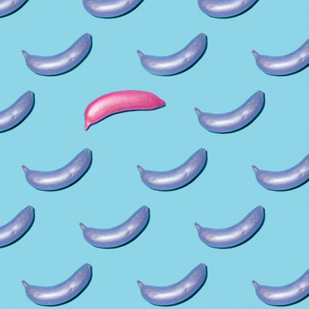 Brightly colored bananas in various shades are patterned on a vibrant blue background, highlighting creativity.の写真素材