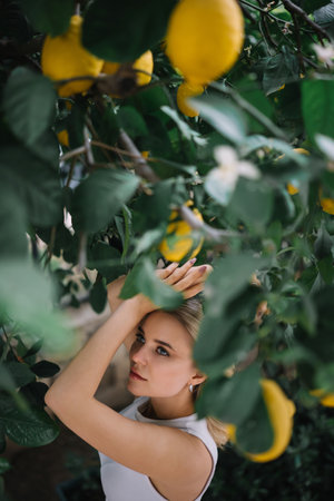 Outdoor portrait of beautiful young woman with healthy skin posing near lemon treeの写真素材