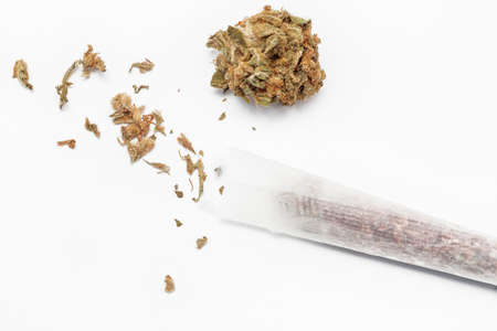 Preparing a cannabis joint with tobacco and rolling paper on white background - top viewの写真素材