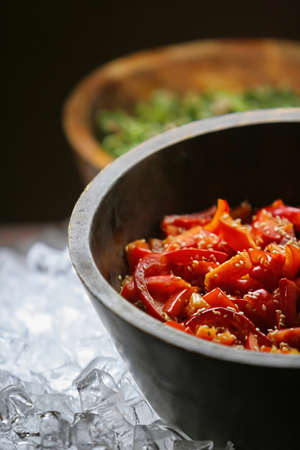 Fresh chopped peppers with sesame served in salad bowls on ice