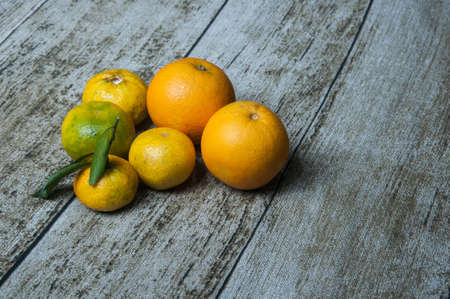 orange and bergamot on top of a wooden tableの写真素材