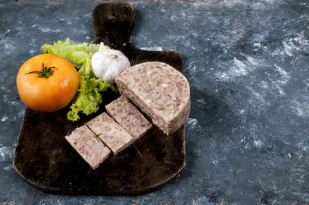 Pork cheese on the table with garlic, lettuce and tomato aroundの写真素材