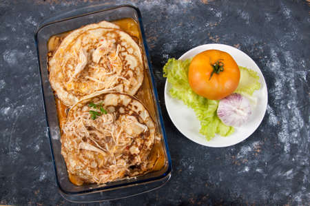 Chicken pancakes with textured background and delivery with tomato, lettuce and garlic on the sideの写真素材