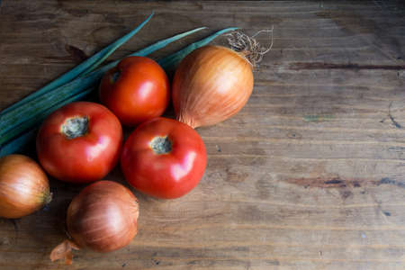 onions and tomatoes on wooden tableの写真素材
