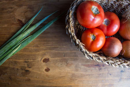 onions and tomatoes on wooden tableの写真素材
